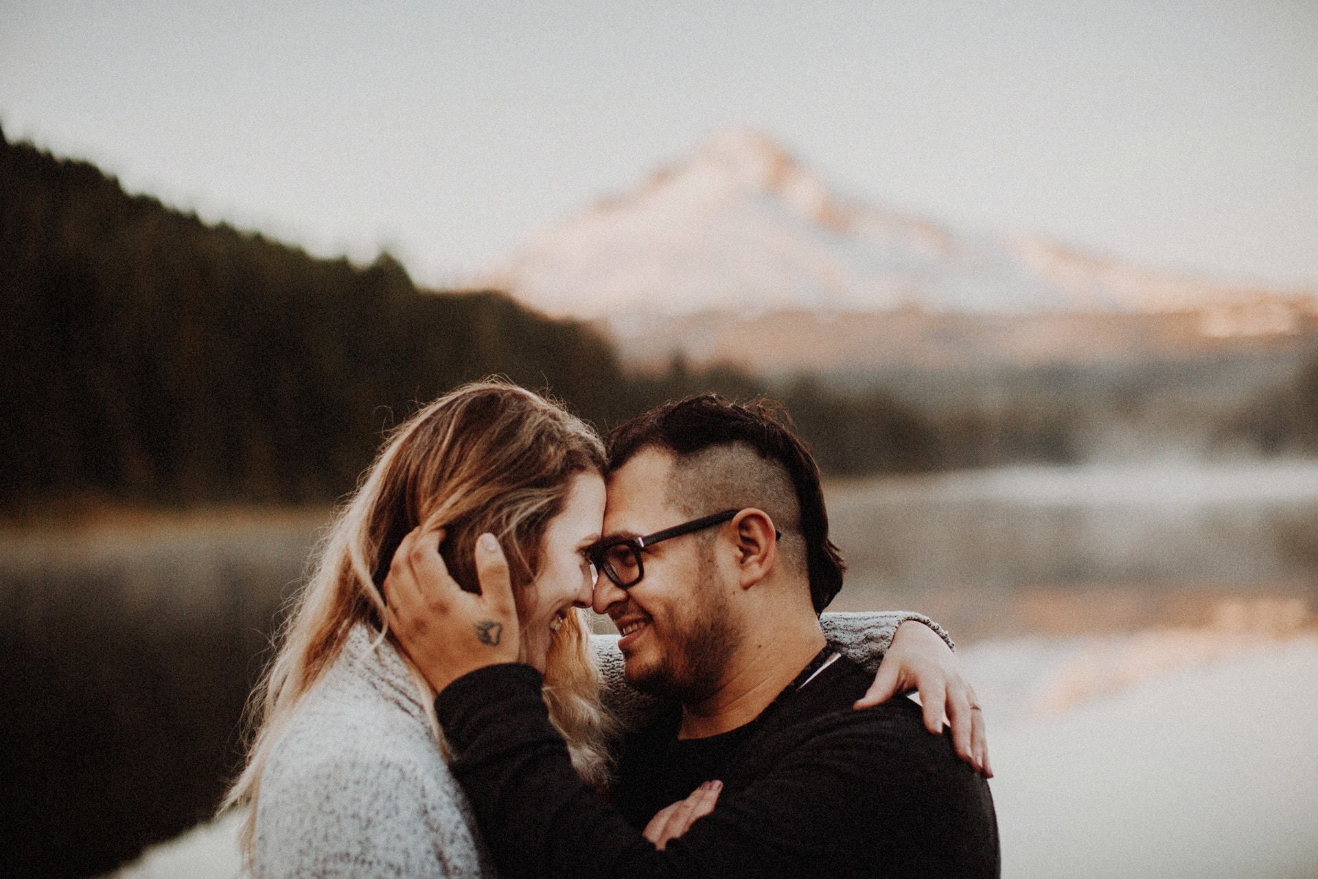 A couple embracing and smiling at Mount Hood