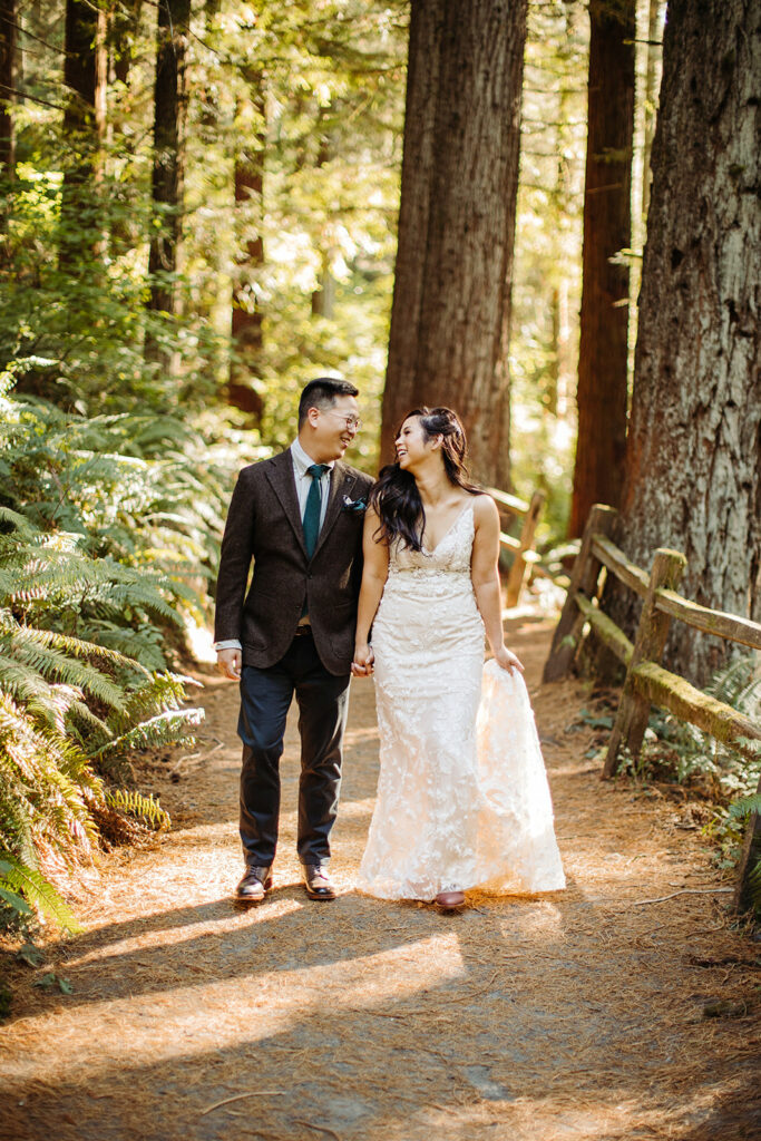 a newlywed couple walking through the forest in oregon